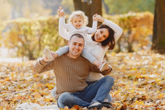 Photo of family of three sitting together on an Autumn evening